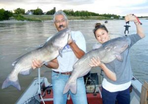 Father and daughter posing with Red River channel catfish