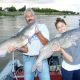 Father and daughter posing with Red River channel catfish