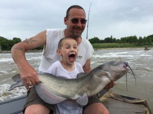 Father and son excitedly holding their big catch with red river catfishing guide blackwater cats 
